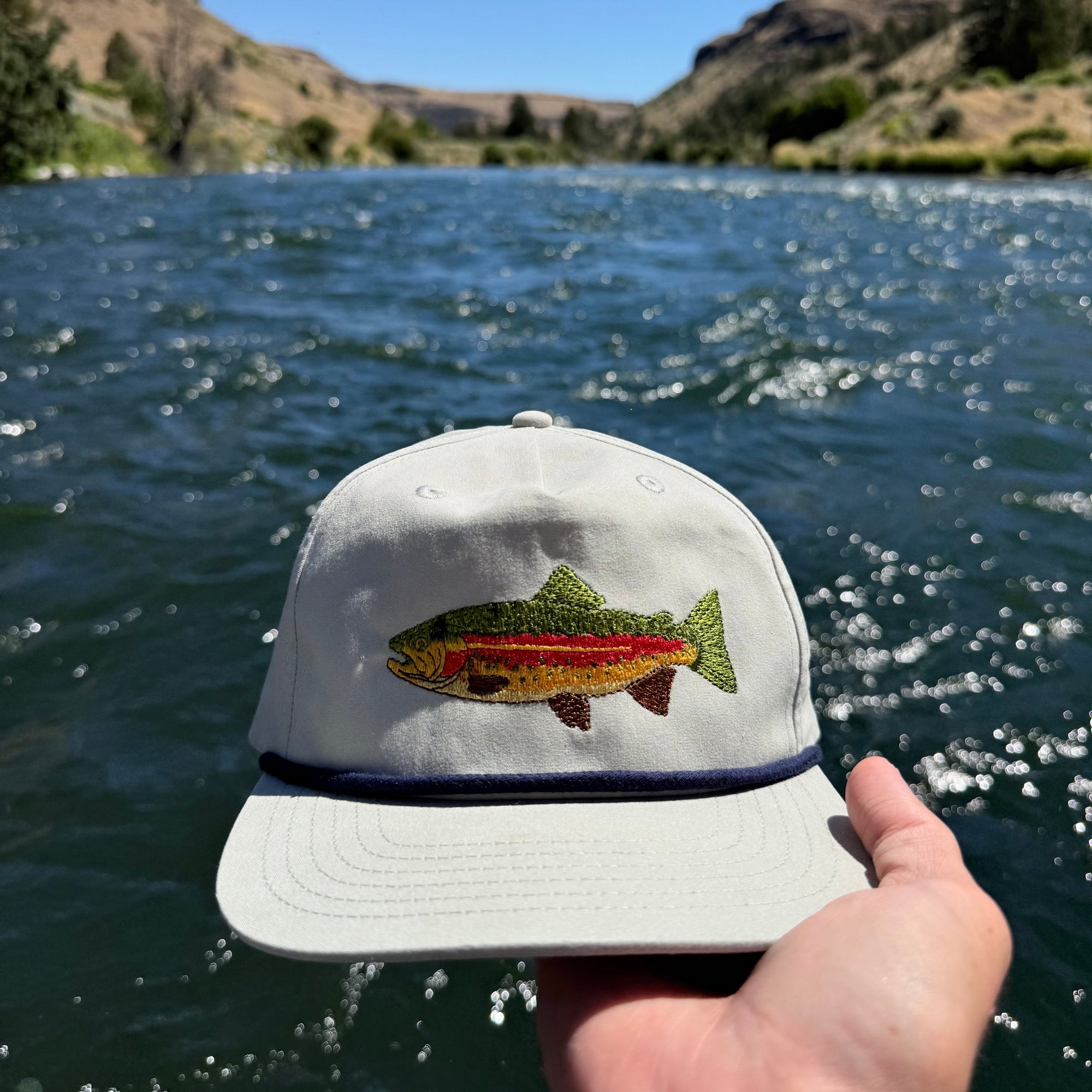 Rainbow trout hat, gray, front view, in river